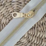Fermeture éclair beige à spirale dorée sur le site Johanna Créations